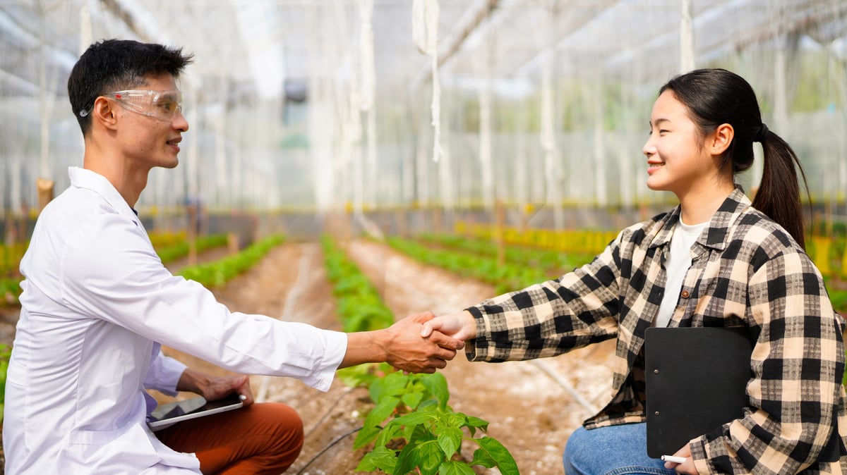 Female hothouse worker shaking hand of agricultural inspector, cooperation.