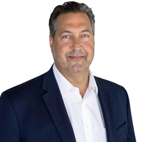 Professional headshot of a middle-aged man in a dark blazer and white shirt against a white background
